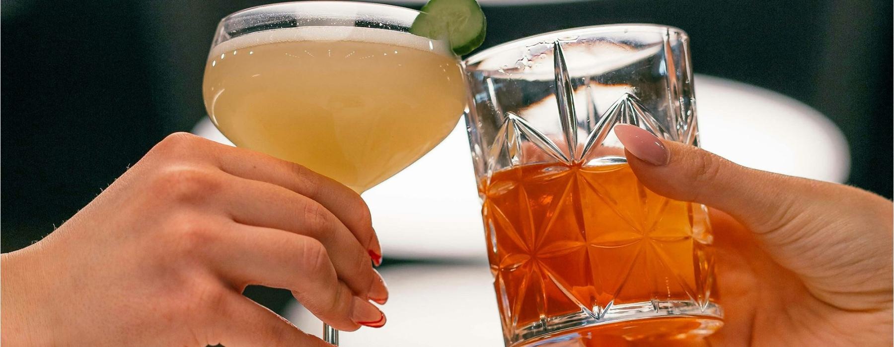 hands holding glasses with cocktails